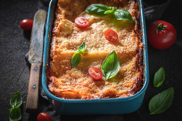Homemade lasagna with bechamel and bolognese sauce. Served with basil.