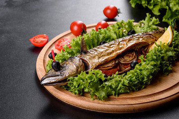 Baked mackerel with vegetables on a wooden board with lemon