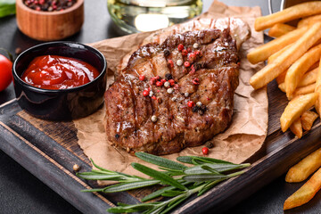 Tasty baked beef steak with vegetables, french fries and spices