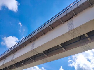 Photo of the LRT train bridge with clouds and sky in the background.