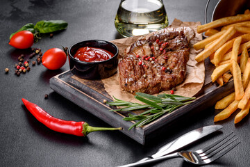 Tasty baked beef steak with vegetables, french fries and spices