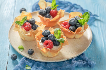 Tasty phyllo cups with berries and cream. Summer dessert.
