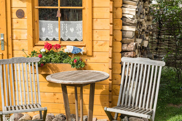 Kleines Gartenhaus im bayrischen Stil mit Sitzgruppe aus Holz