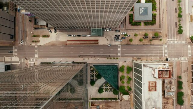 Aerial birds eye overhead top down view of wide multilane downtown streets with low traffic. Horizontally panning view. Dallas, Texas, US