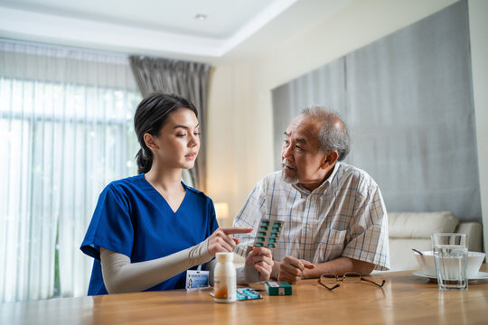 Asian Female Nurse Explaining Medicine Instruction To Old Man Patient.	
