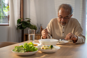 Unhappy Senior Elderly older grandfather eat alone on table in house.	