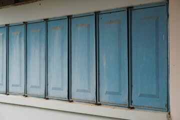 Several blue steel windows on the wall of the building.