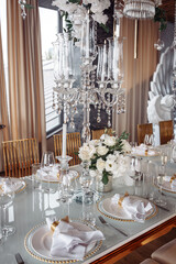 Champagne glasses. Candles and flowers. Banquet table decoration.