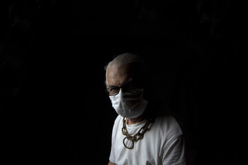 white haired old man with white color health mask on black background.
