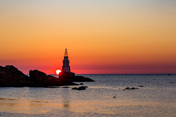 Sun rising behind the lighthouse of Ahtopol, Bulgaria.
Black Sea. Silhouette and cloudless colorful...