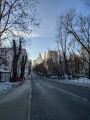 Winter Moscow street leading to Moscow City. People walk along the sidewalk in good clear weather and enjoy the views of Moscow.