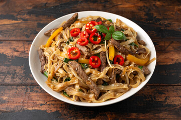 Stir fry Beef Chow Fun with rice noodles, bean sprouts, spring onions and chili.