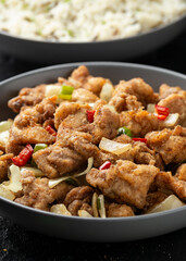 Stir fry chinese salt and pepper chicken with rice in grey bowl
