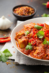 Spicy Chicken Pathia curry with basmati rice in a white plate. healthy food.