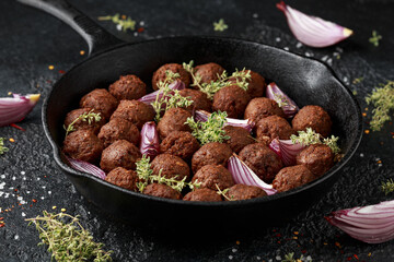 Thyme and onion vegetarian vegan meatballs oven baked in cast iron skillet frying pan