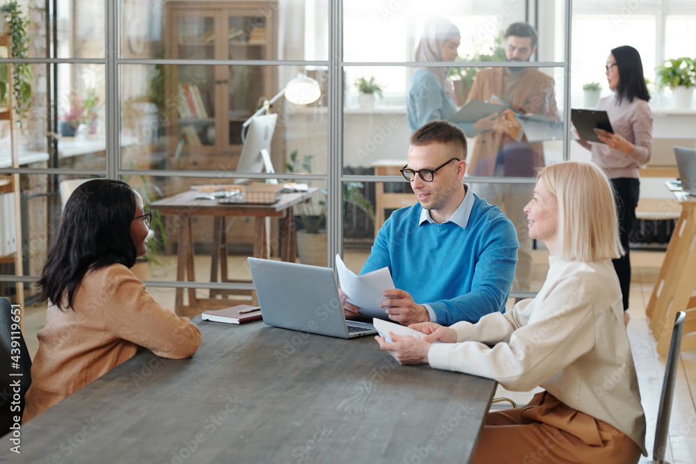 Poster interviewing job candidate in open space office