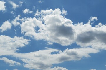 Naklejka na ściany i meble Blue sky background with white fluffy clouds