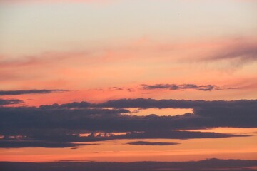 Fototapeta na wymiar Beautiful pink orange sunset in the sky with black clouds on horizon, natural sky background