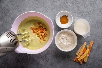 Matcha bread step by step cooking process. Top view. Dark concrete background. Mixing all ingredients together, making dough  and filling metal baking form.