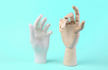 Wooden and mannequin hand on blue background