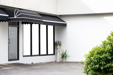 black awning over door and window of shop. shading canvas roof.