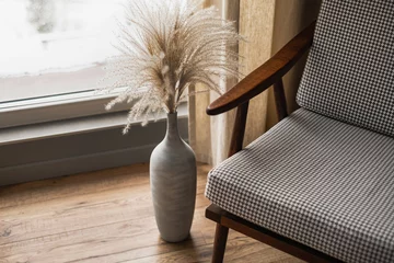 Fotobehang Scandinavisch Mid-century retro chair and pampas grass bouquet in clay pot against window with curtains. Modern aesthetic minimalist home, living room interior design concept  © Floral Deco