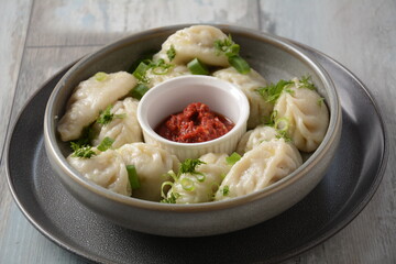 Homemade dumplings, Dagestan cuisine, Kurze. Dumplings kurze with meet filling, and adjika hot sauce  on a plate