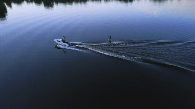 aerial photography, wakeboarding, wakeboarding after a boat at sunset, top view and an athlete falling into the water