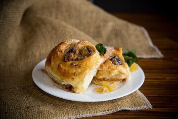 Sweet curled bun with jam, raisins in powdered sugar