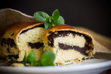 roll with poppy seeds inside on a wooden table.