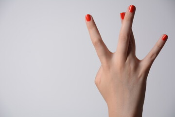 Closeup of female hand showing west side sign isolated on white background