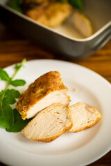 baked chicken fillet pieces with spices and herbs, in a ceramic form