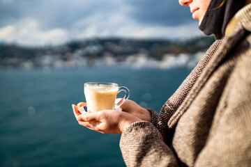 woman drinking masala tea in the front, bosphorus bay in the background