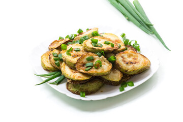 fried zucchini in circles with fresh herbs in a plate isolated on white