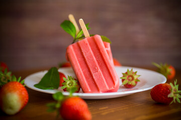 homemade strawberry ice cream on a stick made from fresh strawberries in a plate