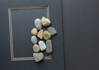 old mat board frame and stones on dark grey board
