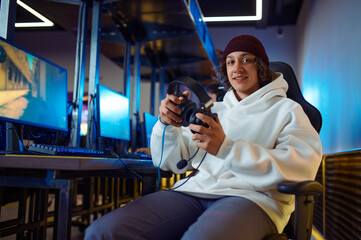 Obraz premium Young cheerful gamer holds headset in game club