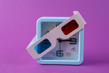 Alarm clock with 3d glasses on purple background