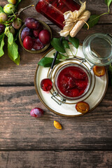 Homemade preservation. Delicious plum jam on a rustic wooden table. Top view flat lay background. Copy space.