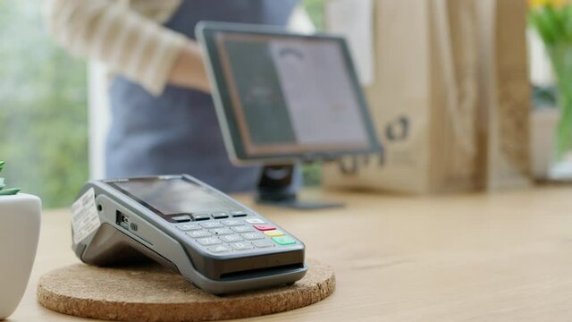 Close-up hand asia woman people work in small sme coffee cafe shop store owner use cashless wifi paywave nfc scan app smart pos reader sale in take out food drink order in urban city life contactless.