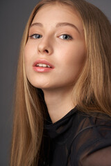 Naklejka premium Natural portrait of young beautiful teen age girl with long straight hair. Female model studio shot against grey background. Pretty girl