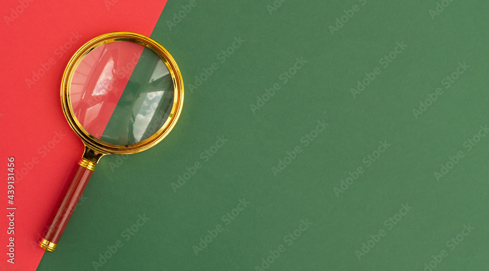 Poster magnifying lens over green and red backgroundwith copy space for text. search tool with copyspace.