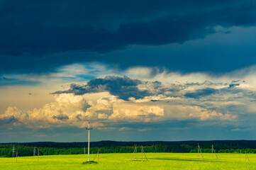 Fototapeta na wymiar Gloomy storm clouds in the sky in a summer field