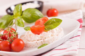 Rice cakes with milk flakes and tomato.