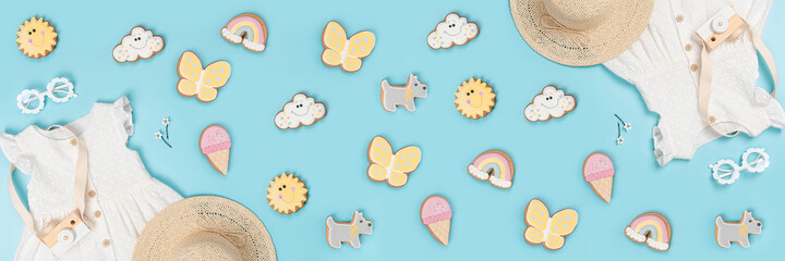 Summer banner made with white dress, the straw hat, sunglasses and funny gingerbread on blue background. Fashion girl lookbook concept. Top view Flat lay
