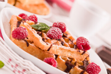 Waffles with raspberries and chocolate cream.