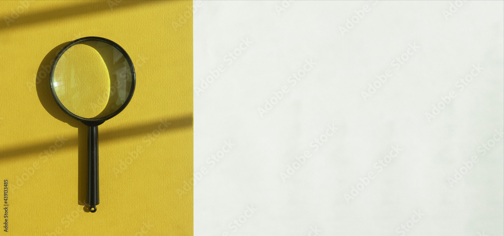 Poster magnifying lens over sunny yellow and white background with day light. search tool concept. banner w