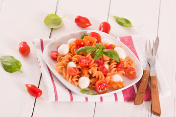 Fusilli pasta with cherry tomatoes and mozzarella cheese.