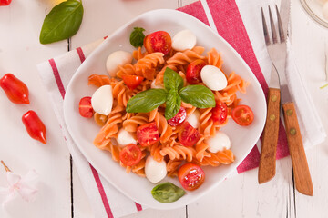 Fusilli pasta with cherry tomatoes and mozzarella cheese.