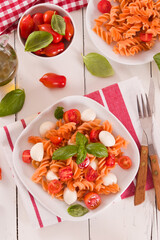 Fusilli pasta with cherry tomatoes and mozzarella cheese.